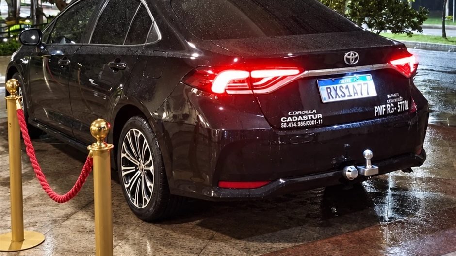 Toyota Corolla preto da VBM na entrada de um hotel à noite