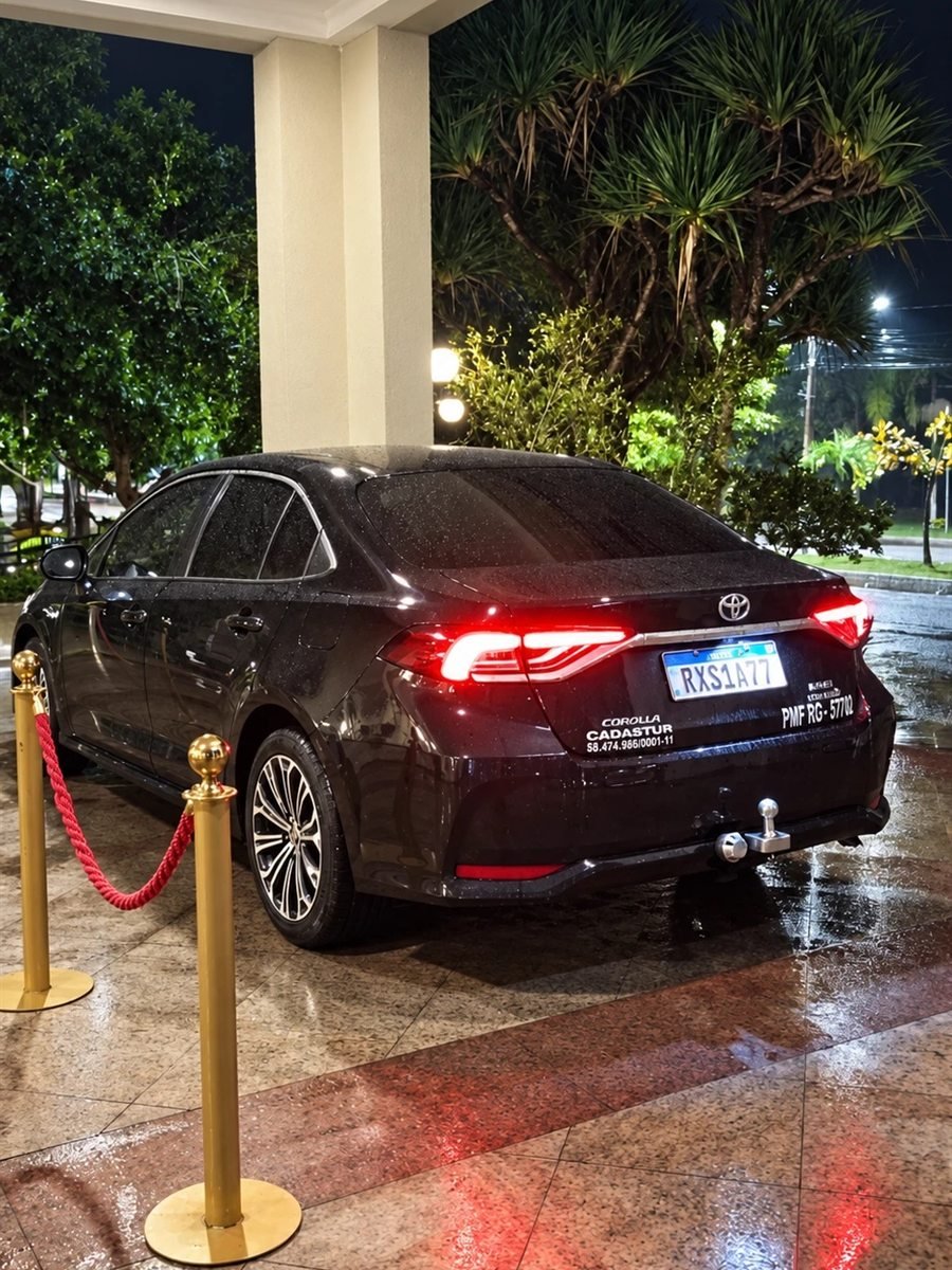 Toyota Corolla preto da VBM na entrada de um hotel à noite